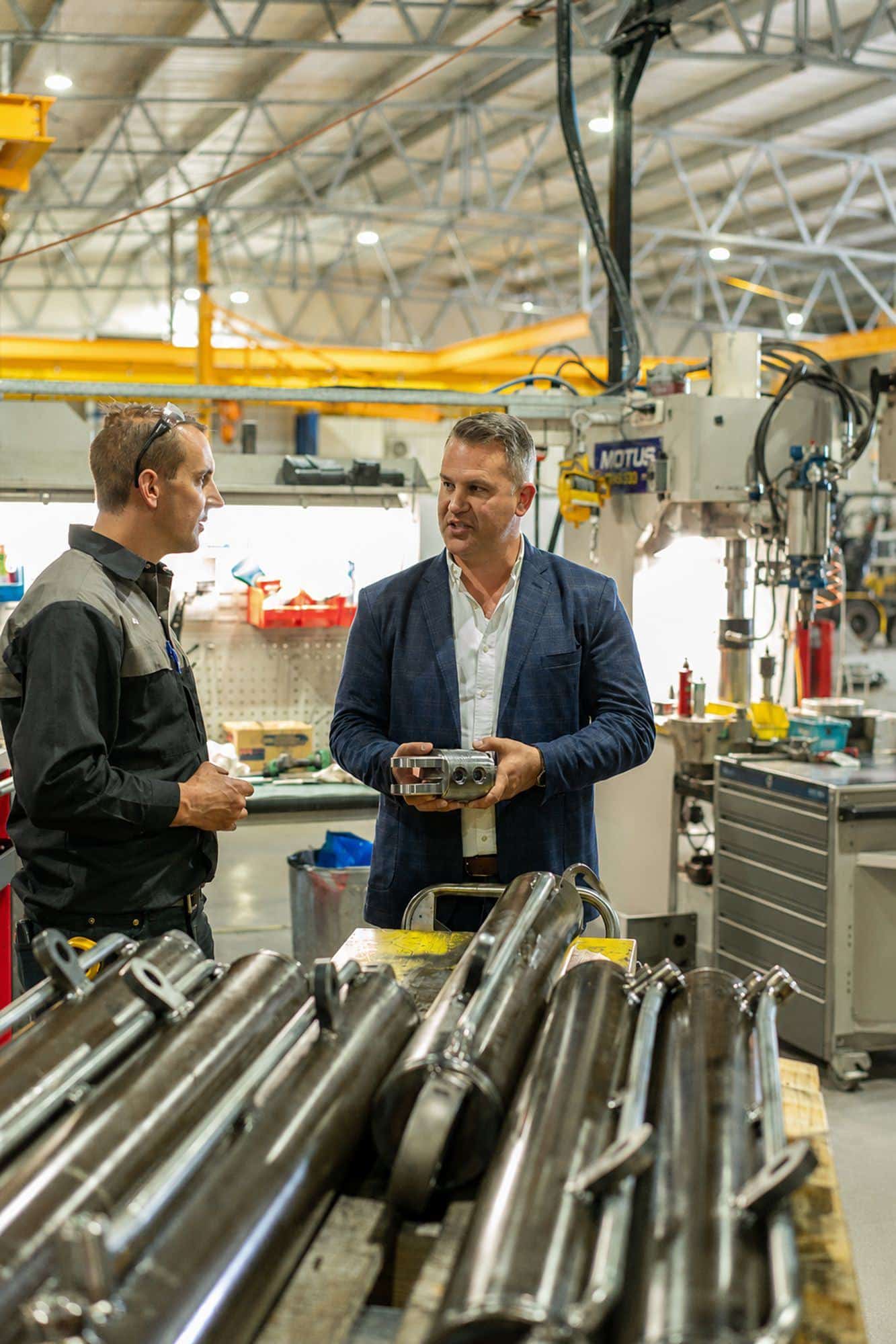Two Motus people talking at a workbench